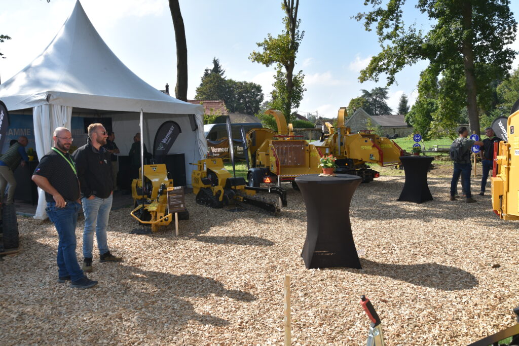 Stand Vermeer France exposant plusieurs broyeurs et machines forestières, avec visiteurs en discussion.