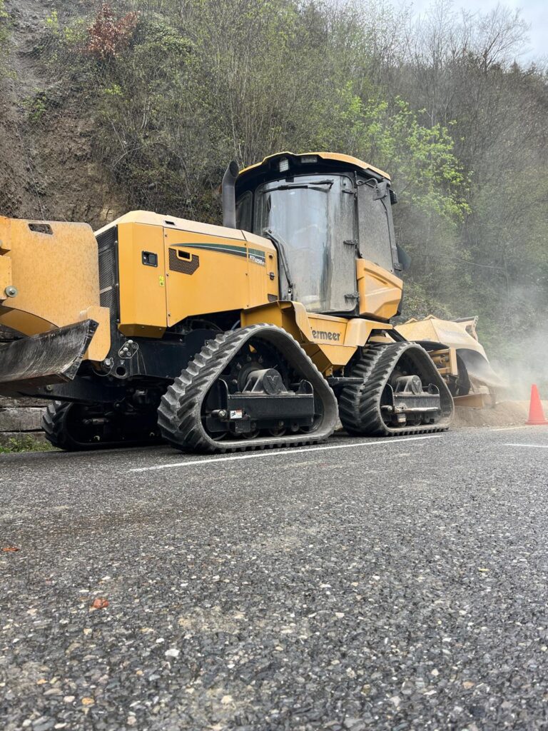Trancheuse Vermeer RTX1250 I2 sur chenilles en travaux de tranchage sur route de montagne